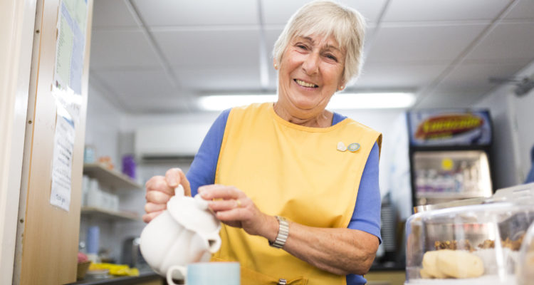 Volunteer pouring tea