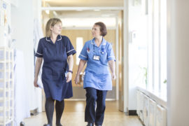 Two staff members walking down the corridor