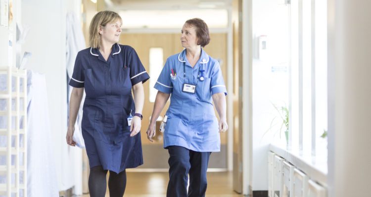 Two staff members walking down the corridor