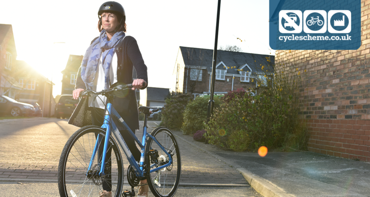 A woman wearing a helmet walking with a blue bike