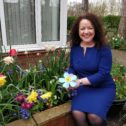 Rachel McMillan sat in the hospice gardenholding a metal forget-me-not