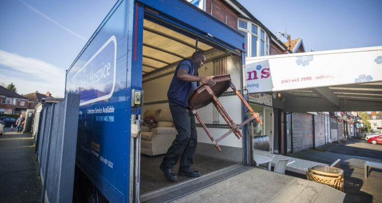 A man carrying a table out of the furniture van