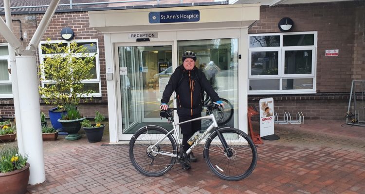 Damian with his bike that he rides to work outside the hospice front entrance